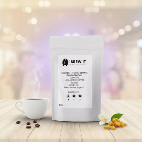 Colombia Marisela Sánchez Geisha (Washed) 250g bag with refined filter brew, warm bokeh, white blossom and golden sultana props.